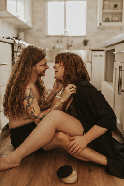 couple laughing and embracing on kitchen floor