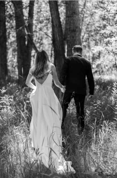 Bride and groom walkng in the woods