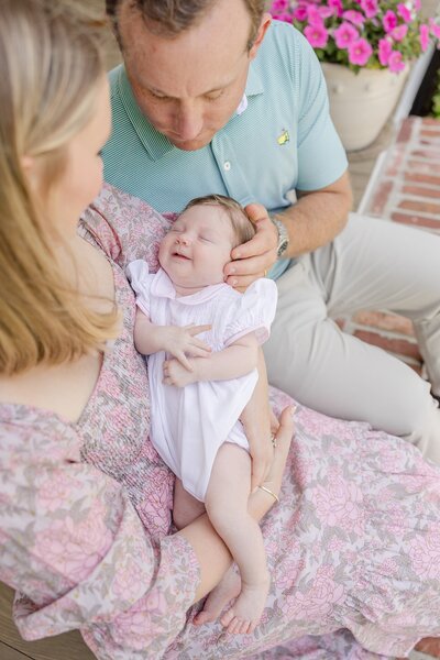 Newborn being cradled in his father's arms.