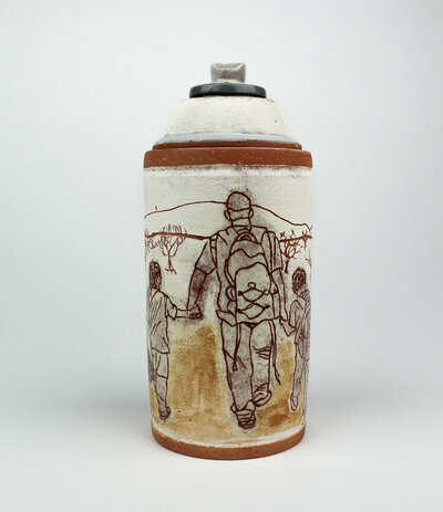 A ceramic spray paint can jar is decorated with imagery of an adult figure holding the hands of two children while walking through the desert