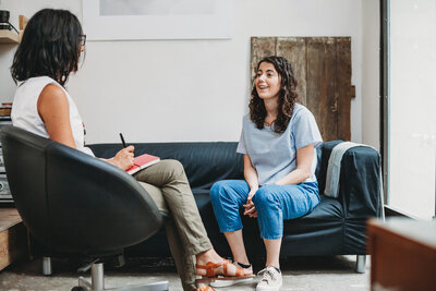Patient and provider sit on couches together at The Practice, which offers mental health therapy services in Tempe, Tucson, and Phoenix, AZ.