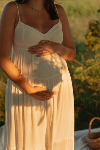 woman holding belly for maternity session in pei