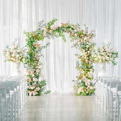 An arch of flowers and greenery at a wedding ceremony at the Science Centre.
