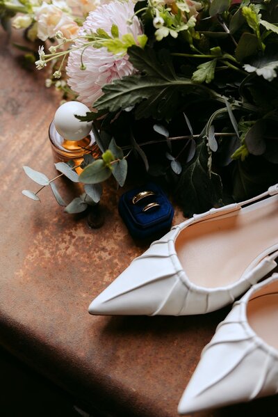 Wedding details with wedding rings and white wedding shoes