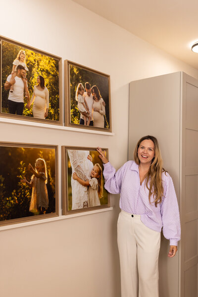 Juliette Laurant poserend in Studio Laurant, lachend kijkend in de camera terwijl zij tussen haar exclusieve kunstwerken staat – een persoonlijk branding portret van Juliette Fotografie.