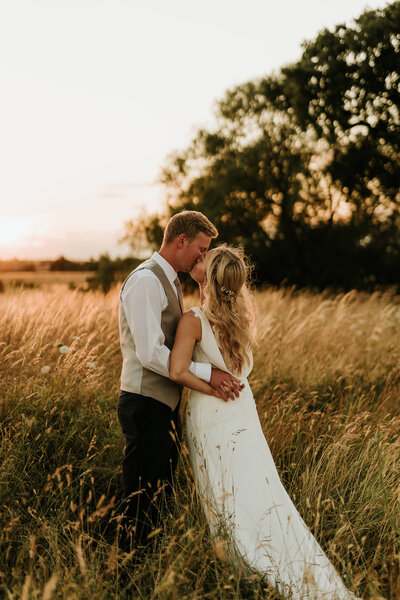 bride and groom in grass field