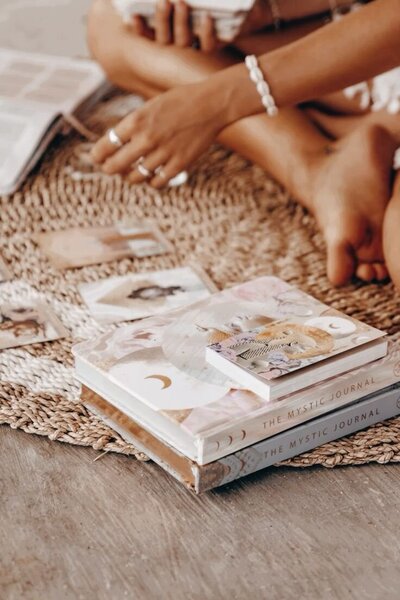 Woman sitting peacefully with oracle cards, reflecting and tuning into her intuition.