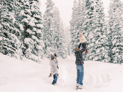 Family playing in snow during their snowy winter photoshoot in Breckenridge