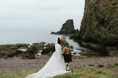 A couple playing in the water near a cave, captured by Longpine Photography.