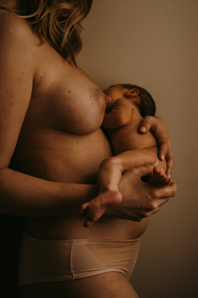 Une femme, jeune maman qui vient de donner naissance à son bébé,  en peau à peau nus l'un contre l'autre