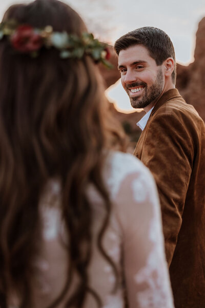 groom smiling back at his bride