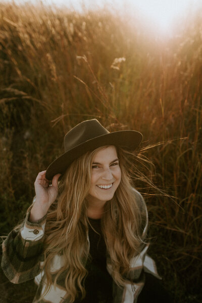 Wedding photographer in a field with a hat on