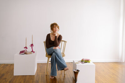woman in brown shirt seated in a chair