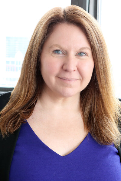 Jade Lambert in a blue top and blazer, founder of Tempest Law, looking confident and approachable
