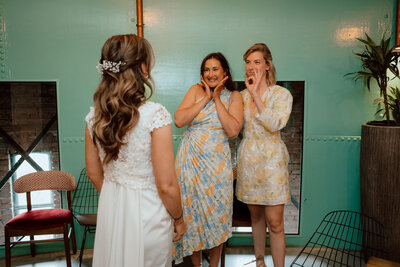 Vriendinnen met liefdevolle blikken die de bruid aankijken tijdens aankleden in De Watertoren Utrecht