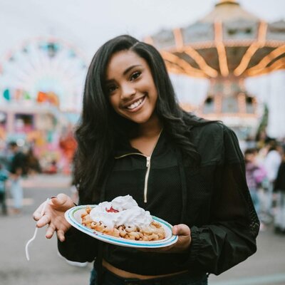A young woman with a funnel cake from the fair