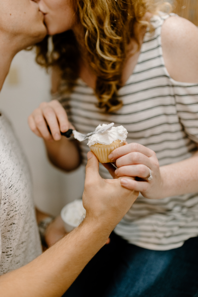 couple kissing and eating cupcakes