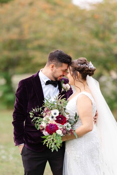 Groom and Bride sharing an embrace in a beautiful autumn field.