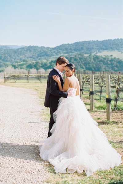 bride and groom embracing in vineyard in santa ynez