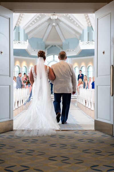 beautiful Disney bride walking down the wedding pavilion aisle together