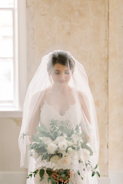 editorial shot of bride in a cathedral veil holding a white cascading bouquet
