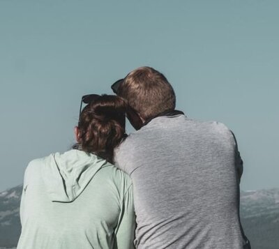 A couple leaning towards each other looking at the view. This can represent a couple who healed from infidelity with Relationship Experts' coaching program. If you are in the aftermath of infidelity and looking to stay together and heal, schedule a free consultation with us!