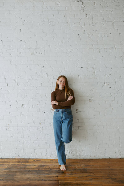 portrait photo of girl with her foot resting against rustic wall | Full Service Wedding Planner| Magnolia Tree wedding 