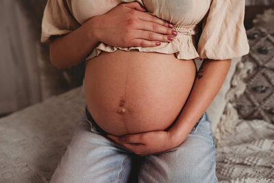 a momma embraces her growing baby bump with a casual, relaxed maternity photosession in the studio of Nikii Pix Photography.