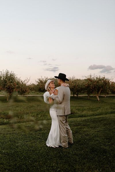 a bride and groom walking together with arms linked