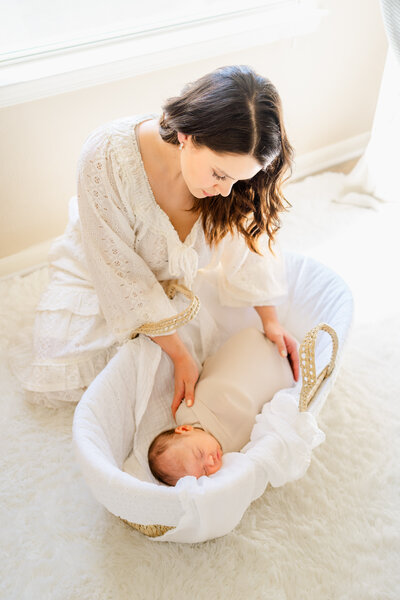 Austin Newborn Photographer | a mother holds her newborn son facing her and rests her forehead on his during an in-home newborn session
