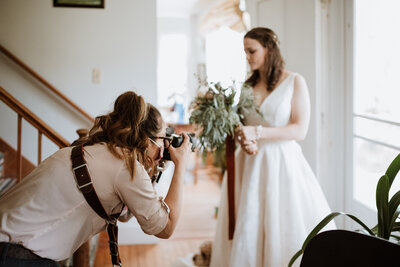 Donna Marie taking a photo of a bride holding her flowers.