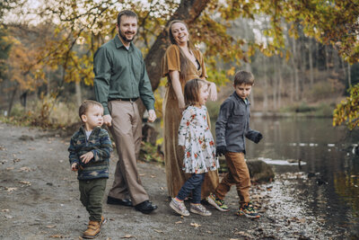 Newborn photographer walking with her family outside.