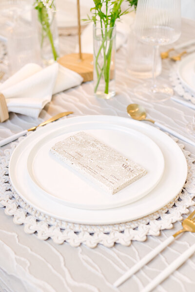 Stone wedding menu with engraved lettering at each place setting — a unique textured detail created by Cove Mill Design Co. for a modern New England celebration.