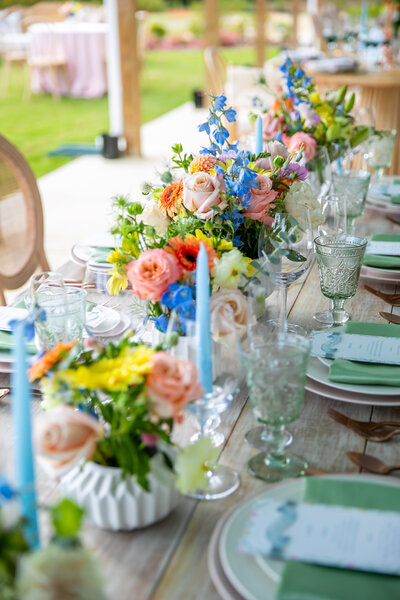 Wedding reception table with pink, orange and tellow floral centerpiece