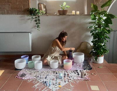 Leah Cavazzini facilitates a crystal sound healing session using alchemy bowls, surrounded by healing crystals and sacred tools, in a serene indoor setting in Sayulita or San Pancho, Mexico.