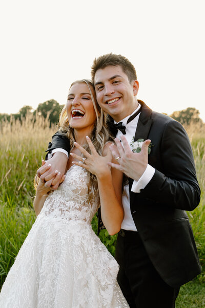 Bride and groom show off their wedding rings