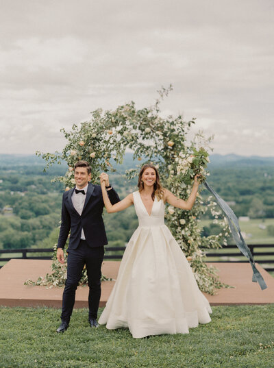 Bride and Groom raise their hands up in celebration after their ceremony at Trinity View Farm in Nashville Tennessee photographed by Nashville wedding photographer Magnolia Tree Photo Company