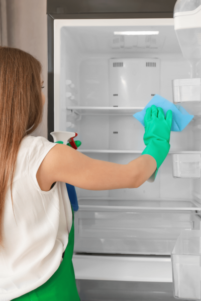 Edmonton Green cleaning technician cleaning a refrigerator interior with natural plant-based products