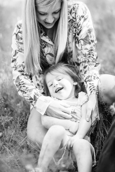 mom tickles daughter's belly