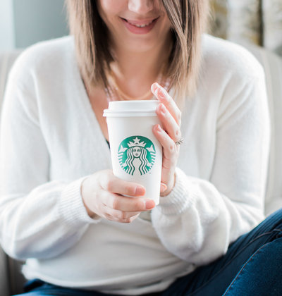 Wedding photographer holding Starbucks coffee