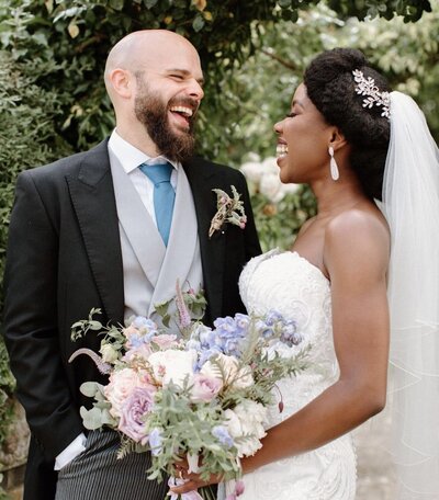 brides and groom smiling at each other