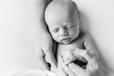 Newborn Baby with Mother's Hands around him