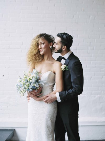 Detail wedding shot of bride holding dress with rose gold ring