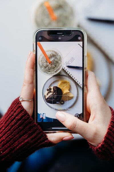 Overhead photo of someone taking an iPhone picutre of Biggby Coffee products.
