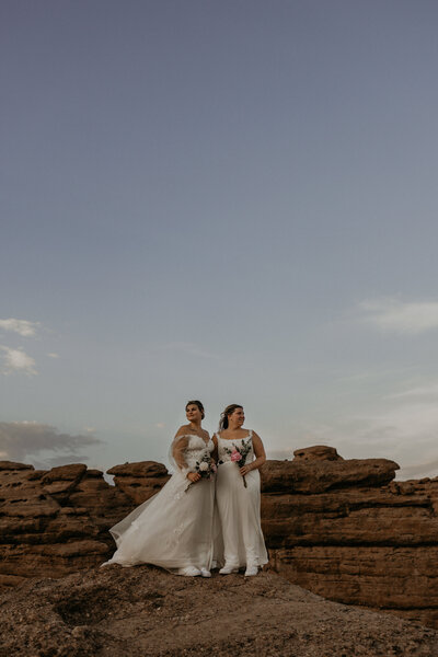 bride and groom kissing infront of red rocks with their dog