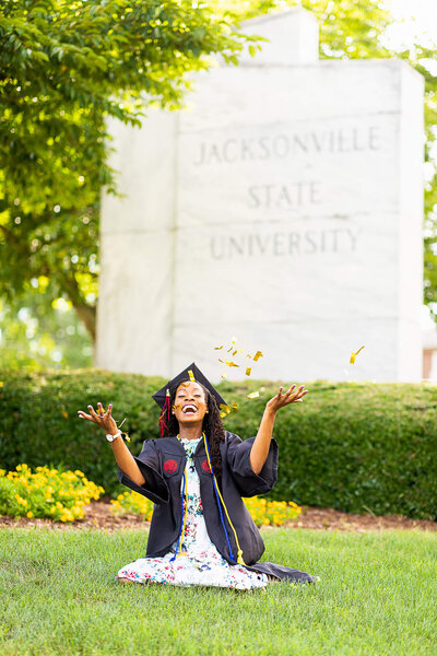 Graduating senior throws confetti in the air at her alma mater