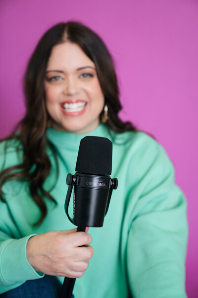 heather smiling with podcast mic