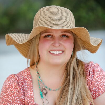 Stacies client Ellie smiling wearing a wavy straw hat