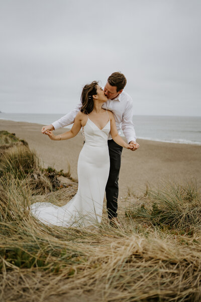 bride and groom kissing on beach