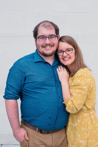 Family photographer Hampton Roads va who specializes in Brand photography poses on a beach with her husband for headshot photos